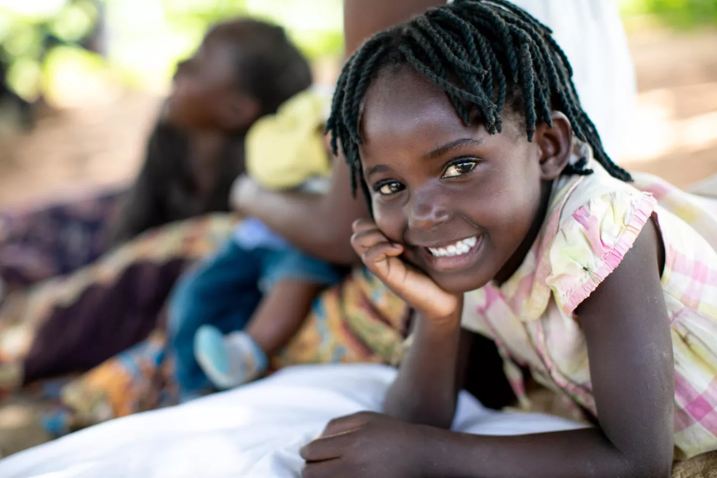 Young girl leans her jaw in her plam, she smiles brightly .
