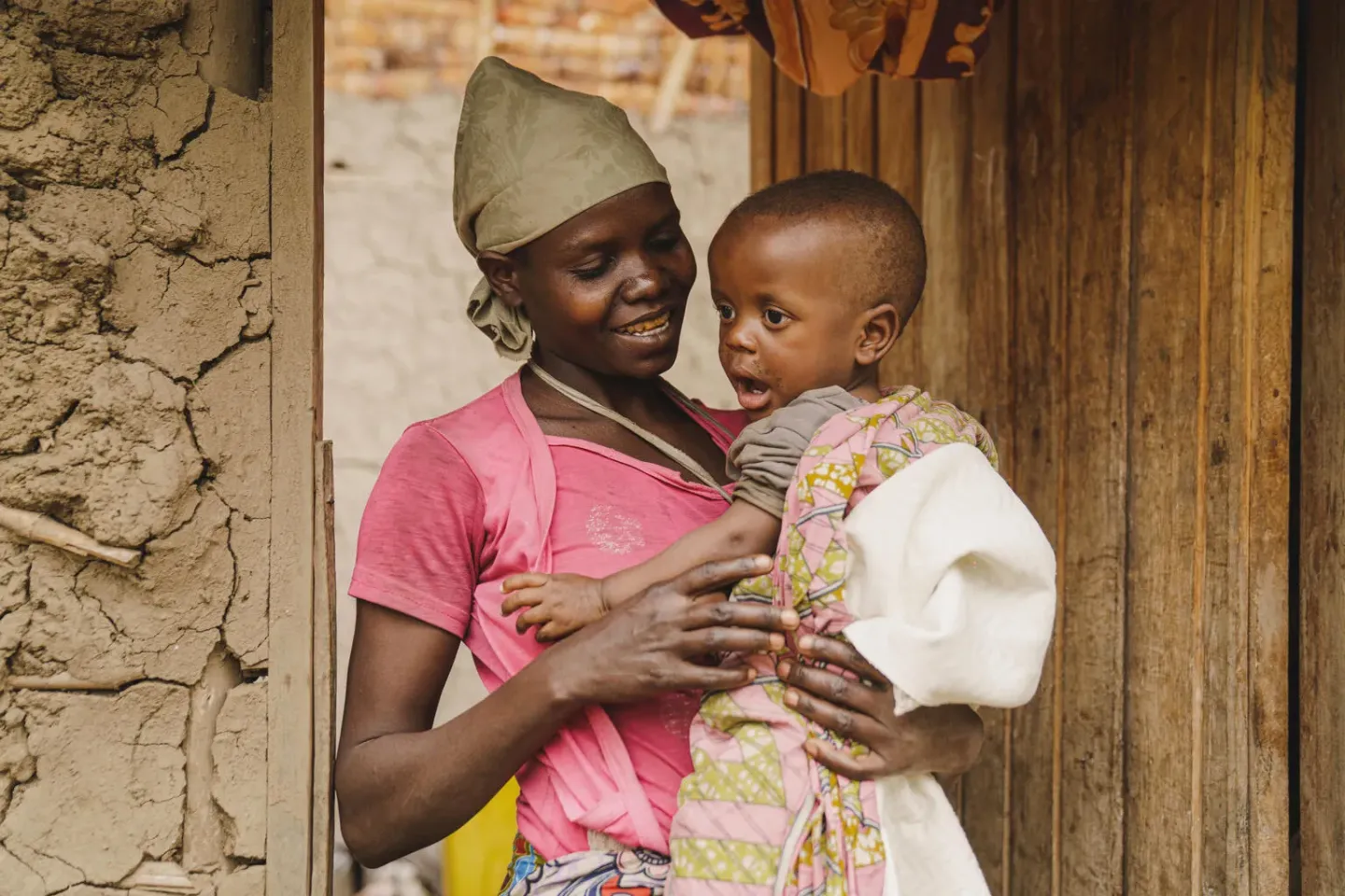 A mother holds her child and smiles