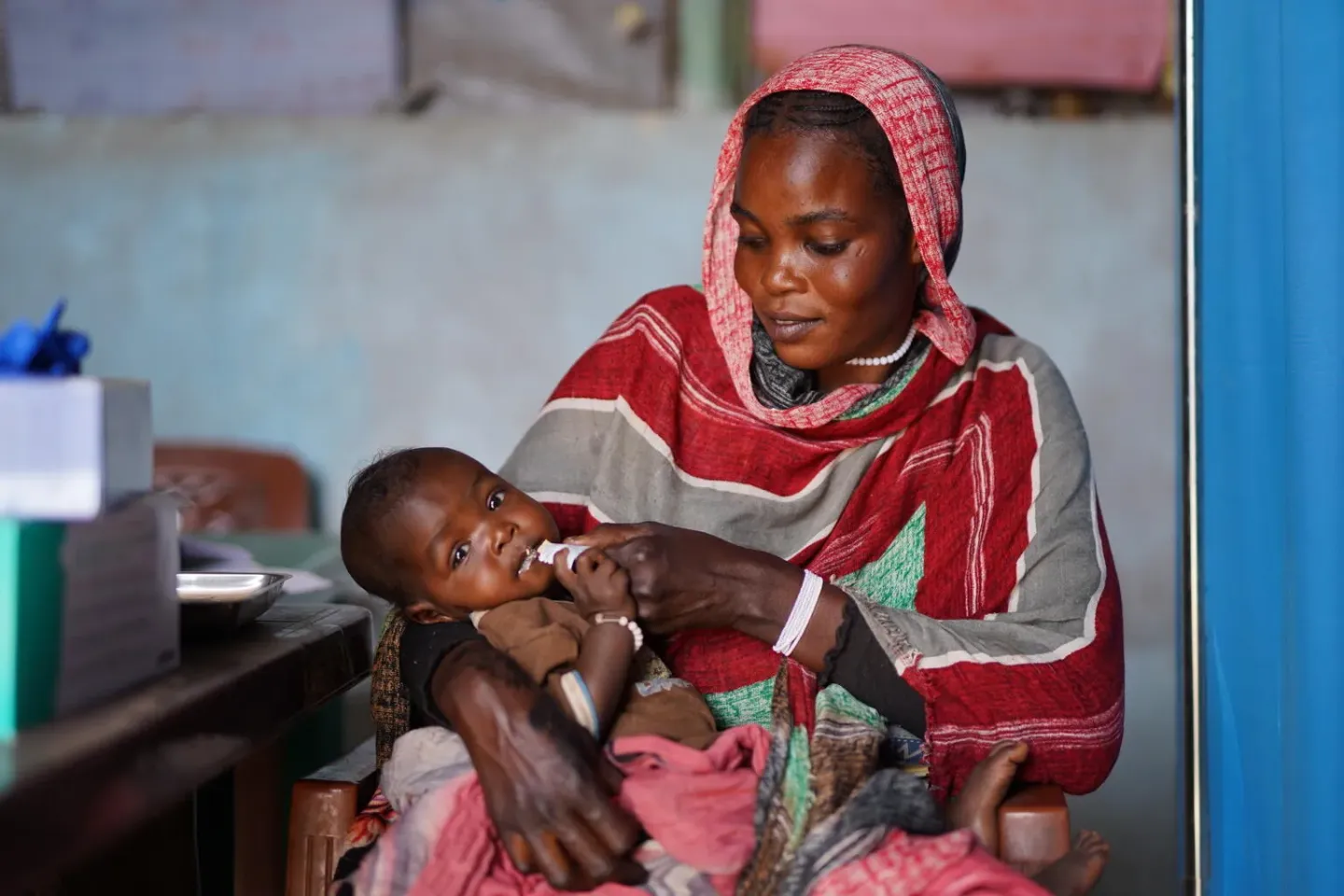 A mother feeds her child with RUTF